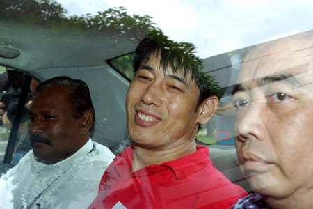 Yishun triple murder Wang in police car smiling